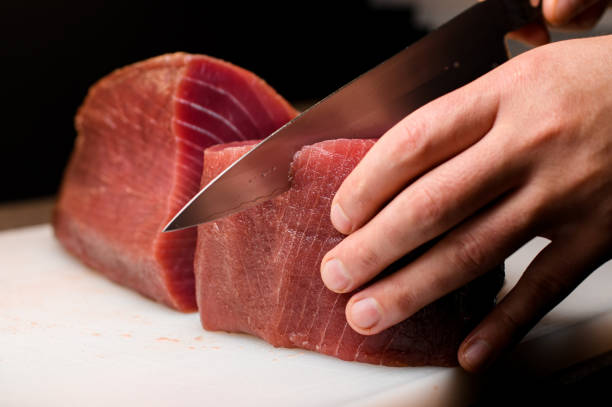 istock Chef cutting on part of yellow fine tuna with sharp Japanese knife 1782609021