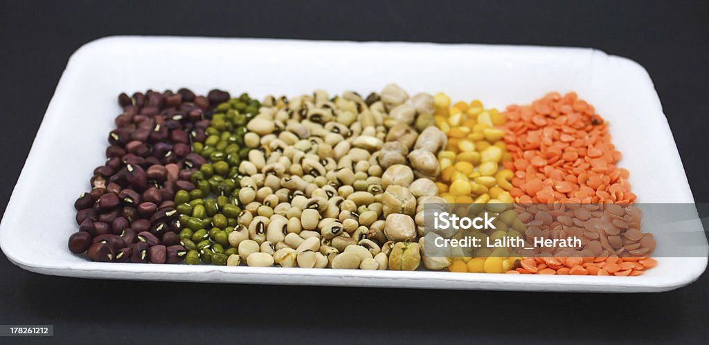 Sementes, grãos na chapa branca em fundo preto vertical - Royalty-free Agricultura Foto de stock