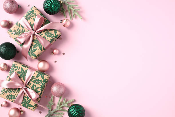 istock Christmas flat lay composition with gift boxes, green baubles, fir branches, decorations on pastel pink background. View from above. 1782625387