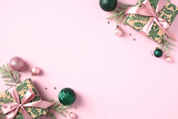 istock Christmas pink background with festive gift boxes, decorations, pink and green baubles on pastel pink table. Flat lay, top view. 1782626542