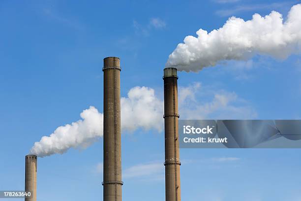 Foto de Industrial Fumaça Pilhas De Uma Usina Elétrica e mais fotos de stock de Alto - Descrição Geral - Alto - Descrição Geral, Azul, Branco