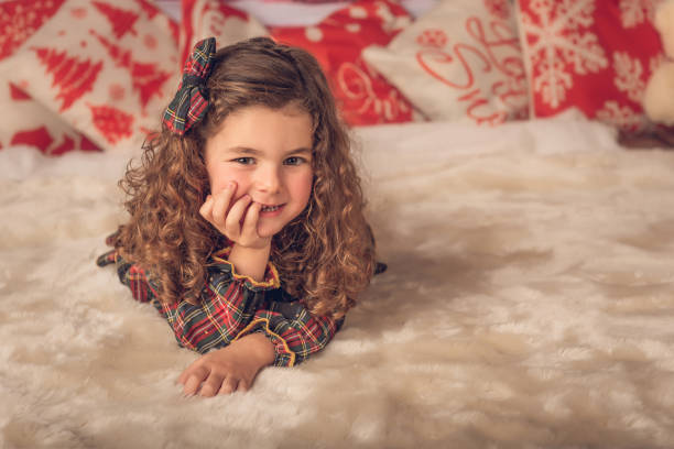 A girl lying on a carpet at Christmas time