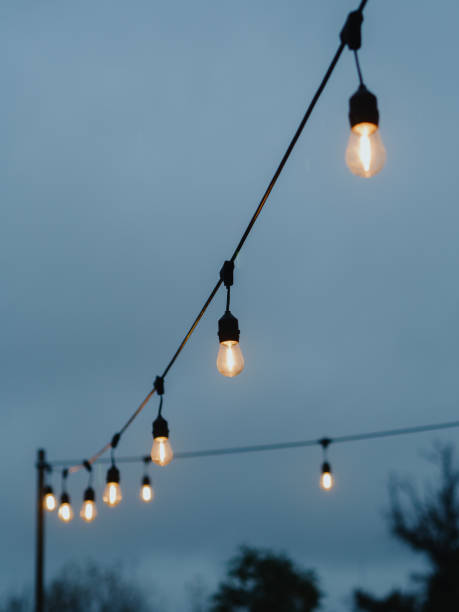 istock Vertical directly below shot capturing two strings of light bulbs against the backdrop of a grey, cloudy dusk sky. November in Warsaw, Poland. 1782638440
