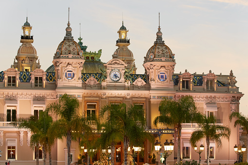 Monaco, Monte-Carlo, 21 October 2022: Square Casino Monte-Carlo at sunny day, a lot of luxury cars, Hotel de Paris, wealth life, tourists take pictures of the landmark, pine trees, blue sky, flowers. High quality 4k footage