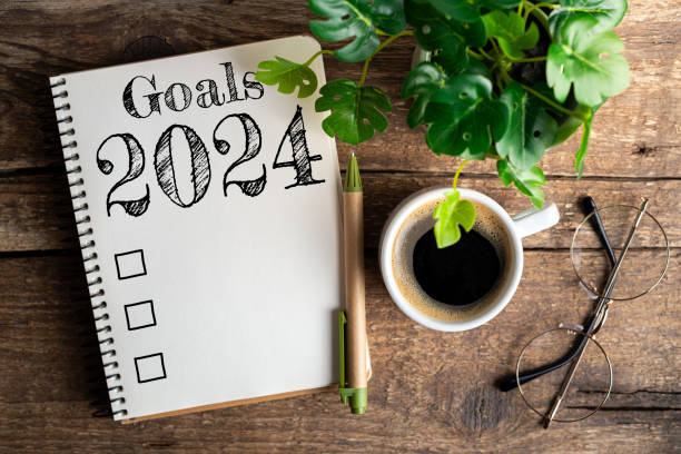 new year goals 2024 on desk. 2024 resolutions list with notebook, coffee cup on table. goals, resolutions, plan, action, checklist concept. new year 2024 template - determination new years eve list aspirations imagens e fotografias de stock