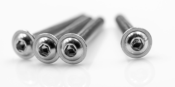 Screws and bolts on white deflective background macro close up