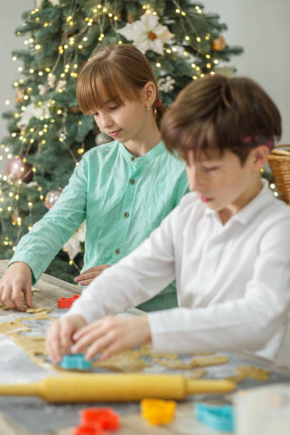 children cooking christmas gingerbread cookies in cozy home kitchen. family traditions. - pastry cutter family holiday child imagens e fotografias de stock