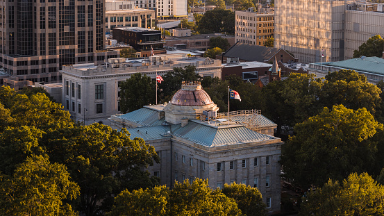 Raleigh, NC historic landmark: North Carolina State Capitol stands surrounded by trees in Downtown Raleigh, NC.