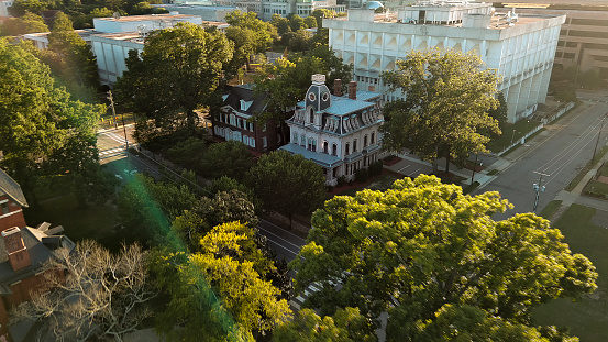 Historic Second Empire style executive mansions – State property contrasts with modern Downtown skyline in Old Raleigh, North Carolina. House for government organizations and commissions