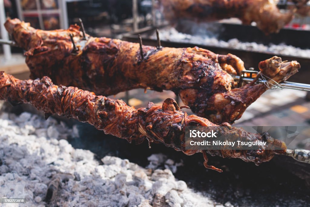 Easter in Greece, process of cooking traditional greek Easter dish - Souvla, grilled lamb, sheep and goat bbq, grilling over charcoal in the streets of Athens, Greece Athens - Greece Stock Photo
