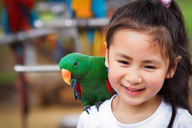 istock cute little girl and parrot 178277658