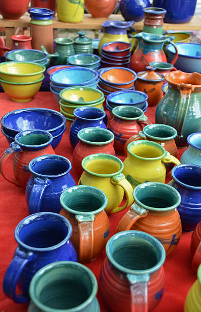 Colorful handmade sandstone pottery for sale Colorful handmade sandstone pottery available for sale at an outdoor market. blue jug stock pictures, royalty-free photos & images