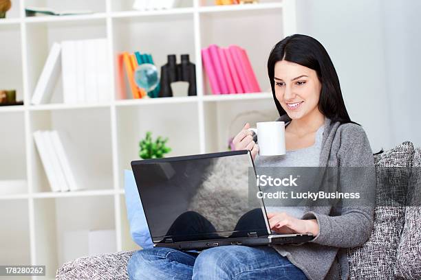 Donna Sorridente Con Il Portatile Bere Caffè - Fotografie stock e altre immagini di Accogliente - Accogliente, Adolescente, Adulto