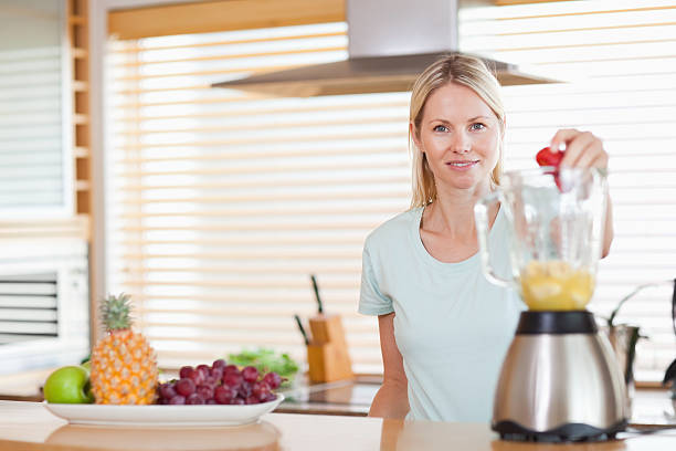 istock Woman dropping strawberry into the blender 178280539