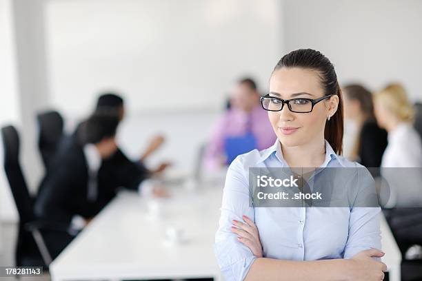 Business Woman Standing With Her Staff In Background Stock Photo - Download Image Now