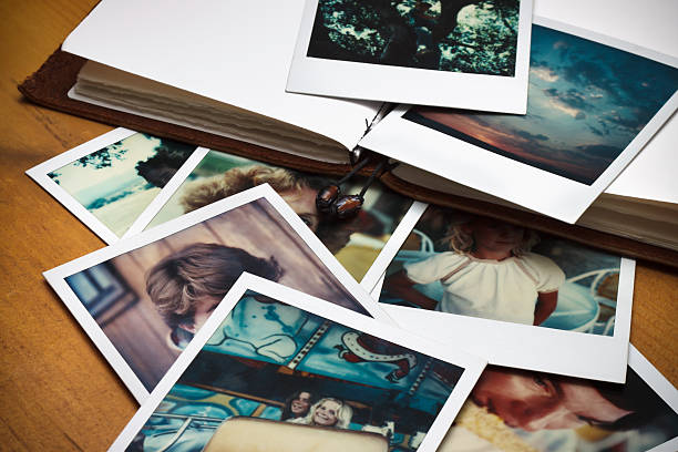Old Pictures and Journal A pile of old pictures and a journal to document memories of past times. photography tables stock pictures, royalty-free photos & images