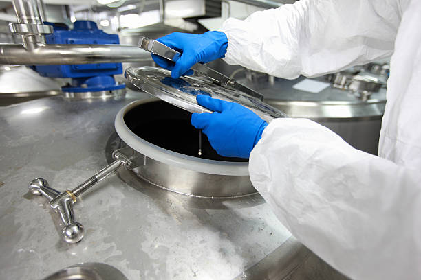 istock hands in gloves opening industrial process tank 178281907