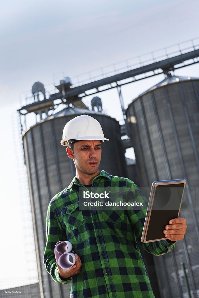 Joven trabajador de construcción revisando su tablet pc - Foto de stock de Accesorio de cabeza libre de derechos