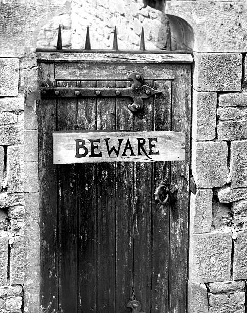 istock beware sign on an old wooden gate with spikes 178286721