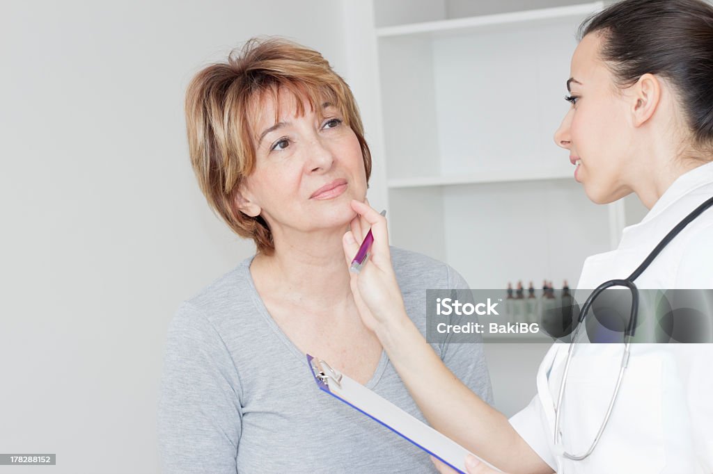 Jeune femme médecin examiner son patient - Photo de Glande thyroïde libre de droits