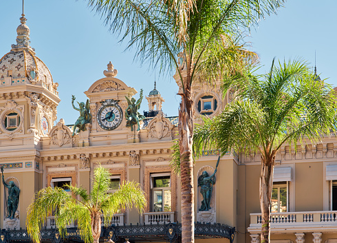 Monaco, Monte-Carlo, 21 October 2022: Facade of Casino Monte-Carlo at sunny day, wealth life, famous landmark, pine trees, blue sky. High quality photo