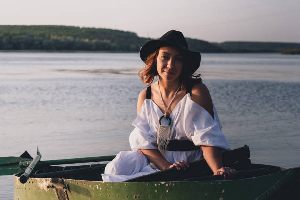 istock Happy bride in black hat in a boat on the river 1782932290
