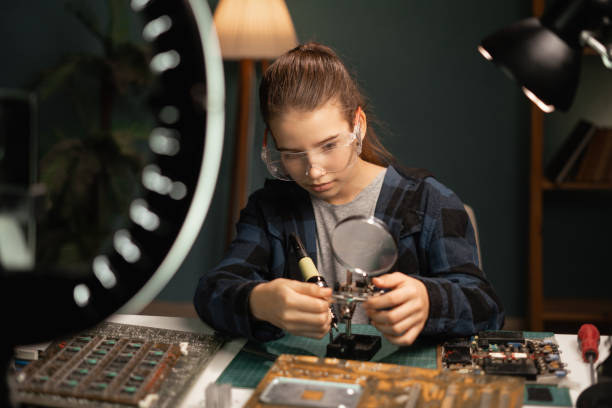 istock Student making video content for social media with smartphone and light of ring lamp talking about soldering circuit board. Child blogger soldering 1782935011