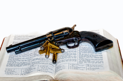 Gun and bullets laying on a bible
