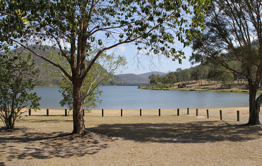 Trees, water, mountains and dam wall at Somerset Dam in Queensland, Australia