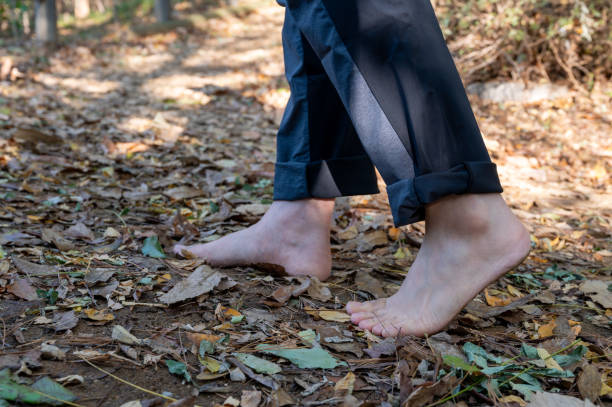 istock A man walking barefoot on a fallen leafy road. Healthy lifestyle concept 1782943427
