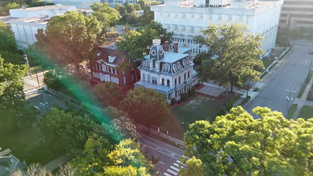 Historic Second Empire style executive mansions contrasts with modern Downtown skyline in Old Raleigh, North Carolina. Aerial footage with forward-panning camera motion