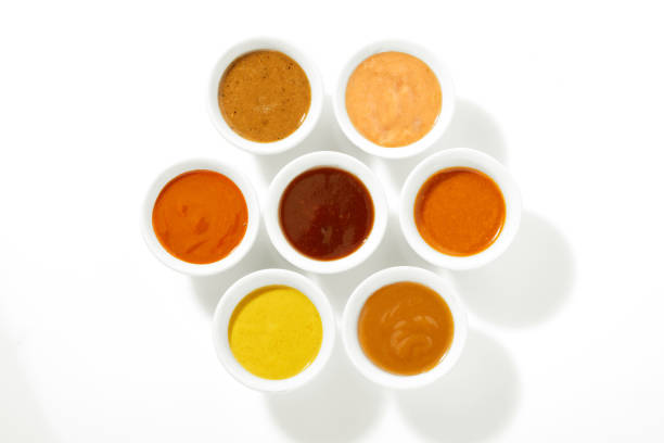 Assortment of Sauces in Ramekins on White Cut out Surface
