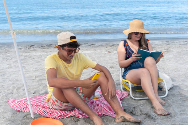 istock Mom reading a book while at the beach with her son 1782975837