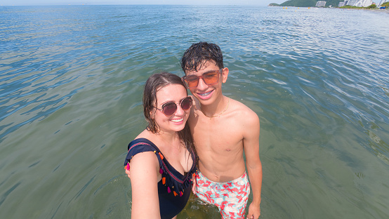 Portrait of a mother and child looking at the camera on vacation at the beach.