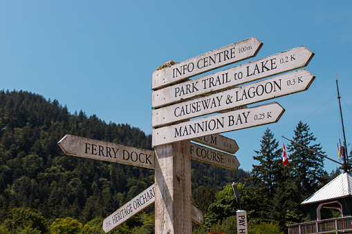 Bowen Island, CANADA - Jun 28 2023 : Iconic wooden signpost near Snug Cove. This signpost showing direction and distance to sightseeing spots on Bowen Island