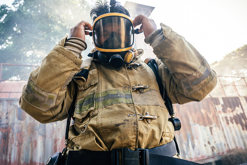 Portrait of firefighter wearing full equipment and emergency rescue equipment at the fire station