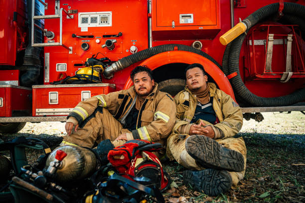 vigile del fuoco esausto che riposa nella caserma dei vigili del fuoco - exhaustion tired men after work foto e immagini stock