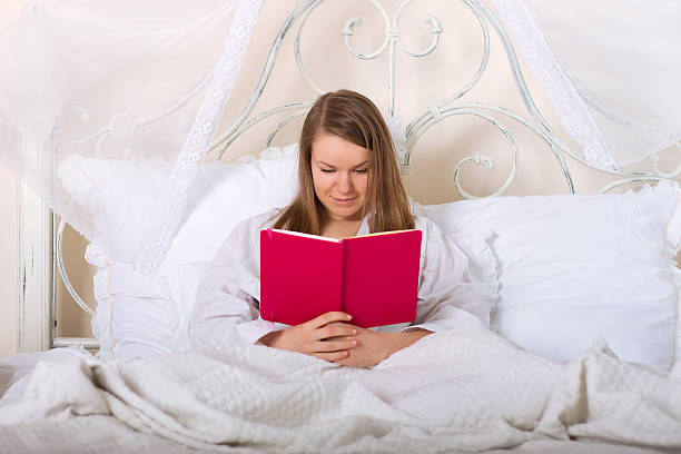 istock Young woman reading in bed 178306543