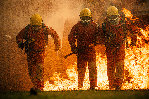 Three fighters running towards the camera in full protective gear at training grounds