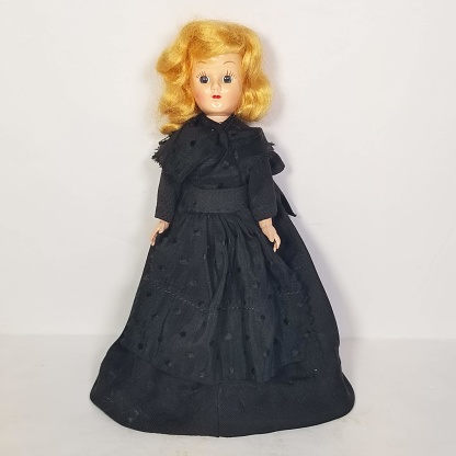 Vintage girl doll toy wearing black dress.