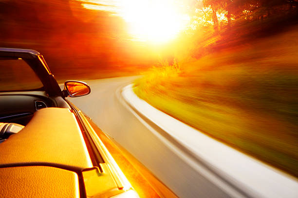 Sunset drive Motion blur shot of drive with a cabriolet in the sunset driving winding road stock pictures, royalty-free photos & images