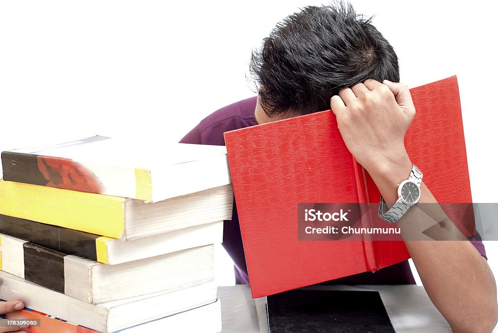 Giovane studente Nascondendo il viso con un libro - Foto stock royalty-free di Adolescente