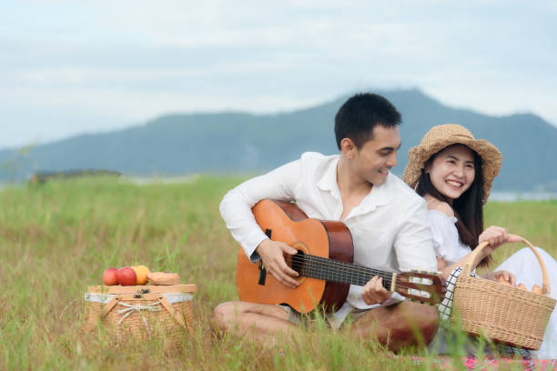 istock Happy couple laughing while reading book at picnic. 1783101485