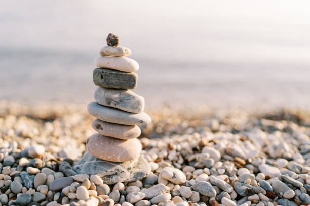 istock Cairn stands casting a shadow on a pebble beach in the sun 1783164406