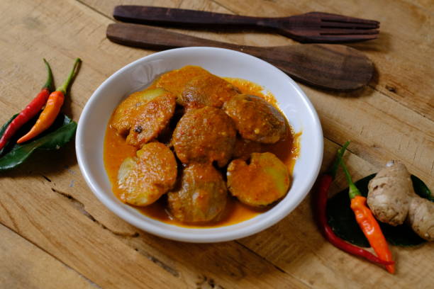istock rendang jengkol is Indonesian food made from jengkol or stinky bean which is processed with spicy rendang spices. served on a white ceramic plate on a wooden table. Pithecellobium jiringa. Indonesian food. 1783167120