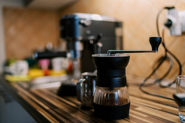 istock Manual coffee grinder with ground coffee stands on the table near the coffee machine 1783203792