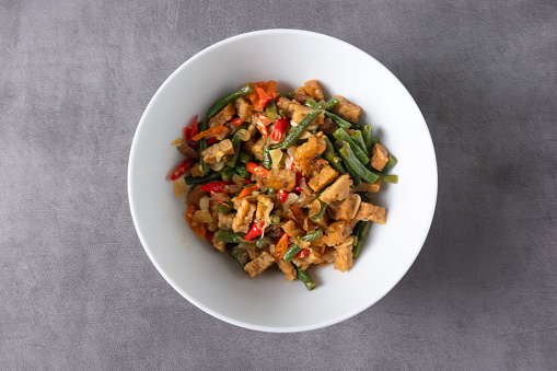 Tofu cubes serving in a bowl, seasoned with black and white sesame and chopped scallion