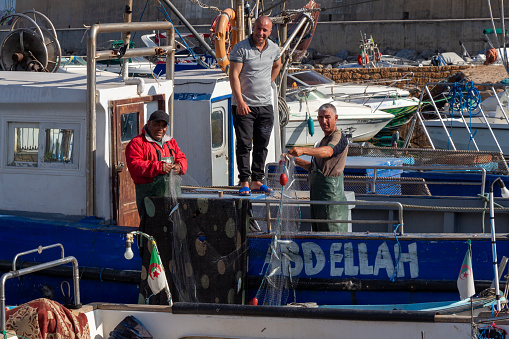 Tipaza (Tipasa), Algeria, April 23 2023 : Algerian fishermen working in their boat in the old fishing port.