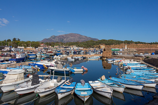 Tipaza (Tipasa), Algeria, April 23 2023 : beautiful panoramic view of the old port, with fishing boats, mountains in the background and blue sky.
