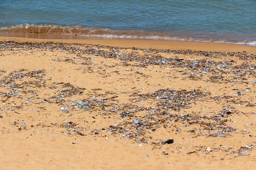 Polluted beach with numerous plastic waste on a beach of the Mediterranean sea in Tipasa, Tipaza, Algeria.